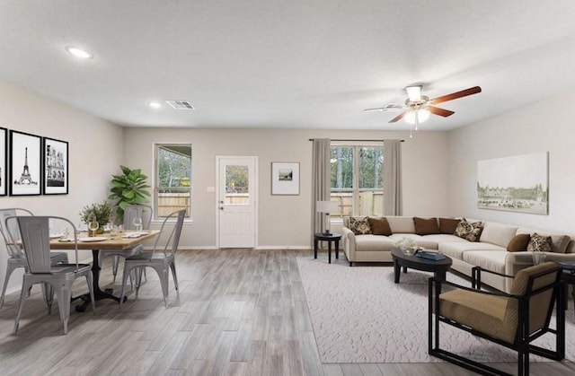 living area featuring light wood-type flooring, baseboards, visible vents, ceiling fan, and recessed lighting