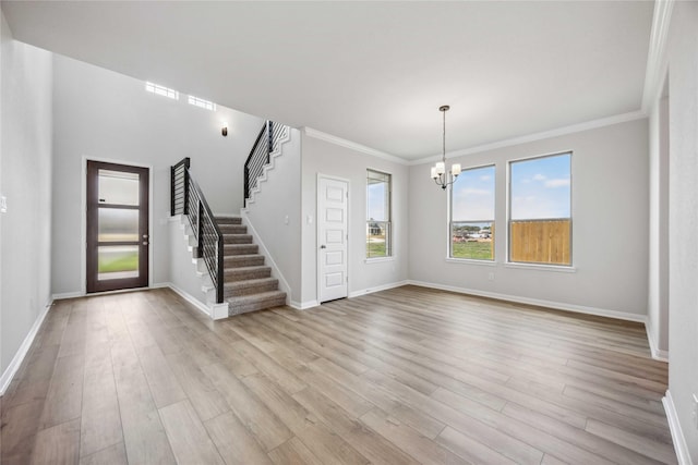 entrance foyer featuring crown molding, stairway, baseboards, a chandelier, and light wood-style floors