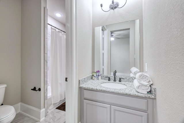 17473 Chestnut Cove Dr, Conroe, TX 77302 - bathroom featuring toilet, vanity, a textured wall, a ceiling fan, and marble finish floors