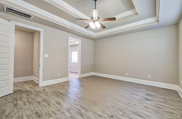 17473 Chestnut Cove Dr, Conroe, TX 77302 - spare room featuring a tray ceiling, ceiling fan, ornamental molding, wood finished floors, and baseboards