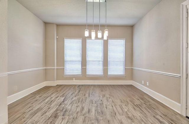 17473 Chestnut Cove Dr, Conroe, TX 77302 - empty room featuring wood finished floors, baseboards, and healthy amount of natural light