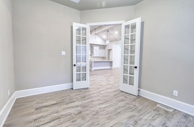 17473 Chestnut Cove Dr, Conroe, TX 77302 - empty room with french doors, wood finished floors, and baseboards