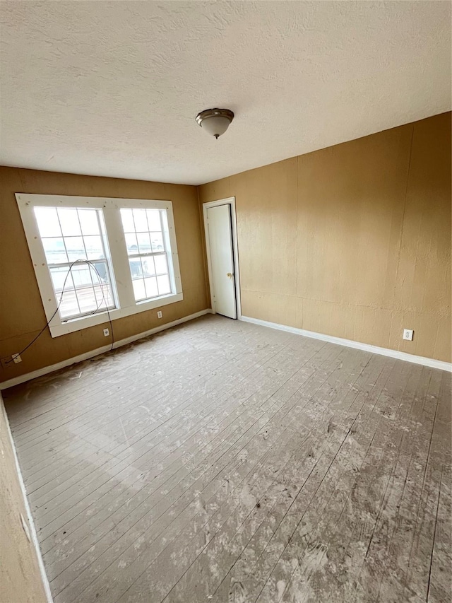 4839 Gulf Fwy Unit 6, Houston, TX 77023 - unfurnished room with baseboards, a textured ceiling, and hardwood / wood-style floors