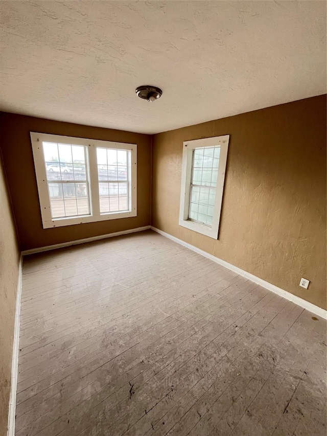 4839 Gulf Fwy Unit 6, Houston, TX 77023 - empty room featuring a textured wall, hardwood / wood-style flooring, baseboards, and a textured ceiling