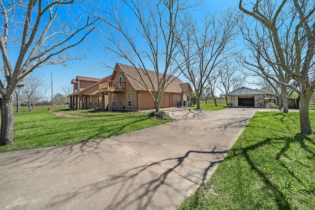 view of front of home with a front yard, a garage, and brick siding