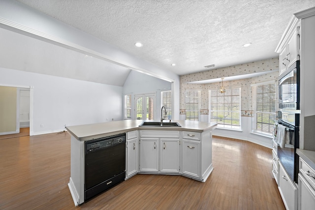 kitchen featuring open floor plan, light countertops, a sink, and black appliances