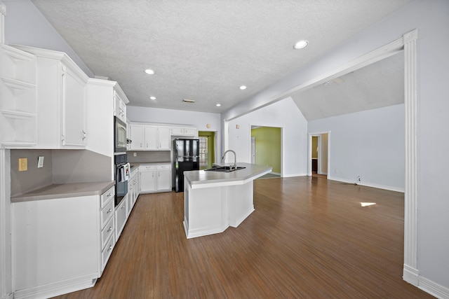 kitchen featuring open shelves, dark wood finished floors, a sink, a kitchen island with sink, and black appliances