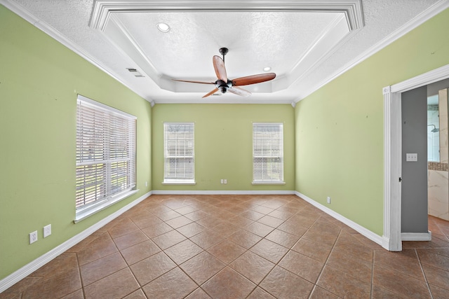 empty room featuring a ceiling fan, visible vents, a tray ceiling, and a textured ceiling