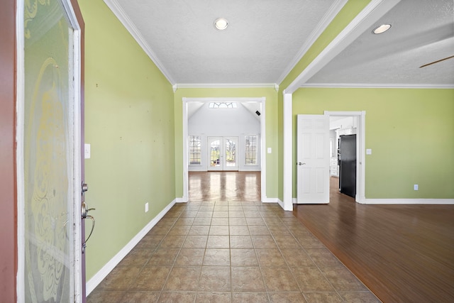 foyer with baseboards, crown molding, tile patterned flooring, and a textured ceiling