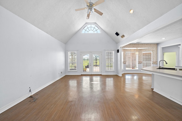 unfurnished living room featuring a sink, hardwood / wood-style flooring, a textured ceiling, and ceiling fan