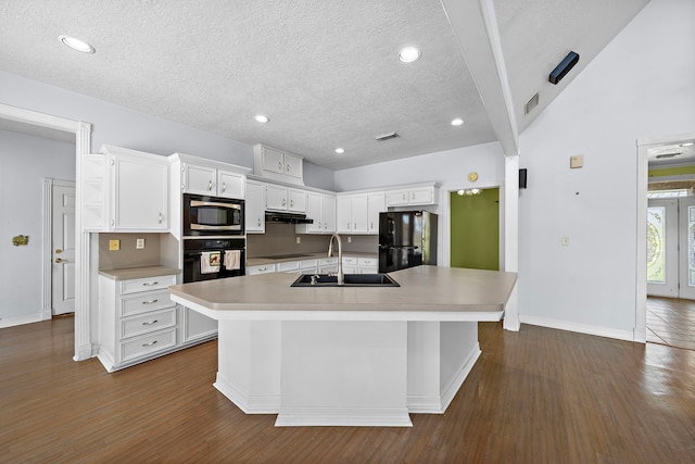 kitchen with a sink, under cabinet range hood, white cabinetry, and black appliances