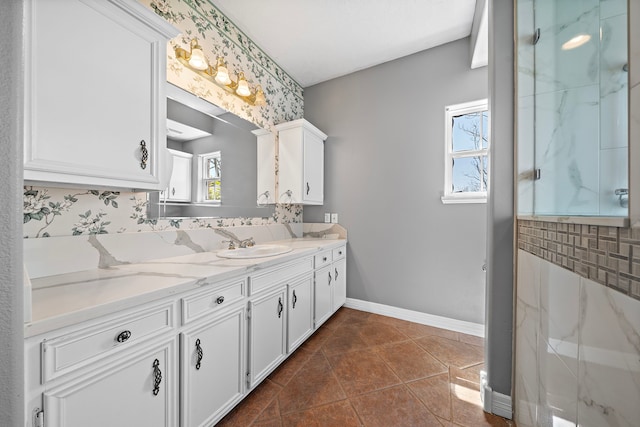 full bath featuring tile patterned floors, vanity, a marble finish shower, tasteful backsplash, and baseboards