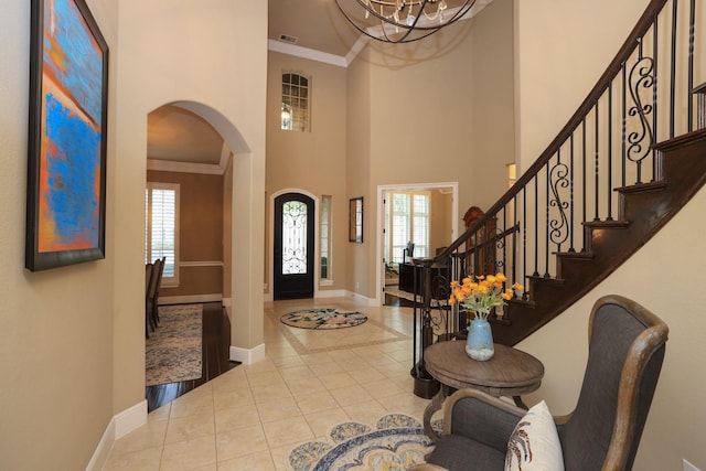 15614 Lake Iris Dr, Houston, TX 77070 - tiled entryway with arched walkways, a towering ceiling, a chandelier, stairs, and ornamental molding