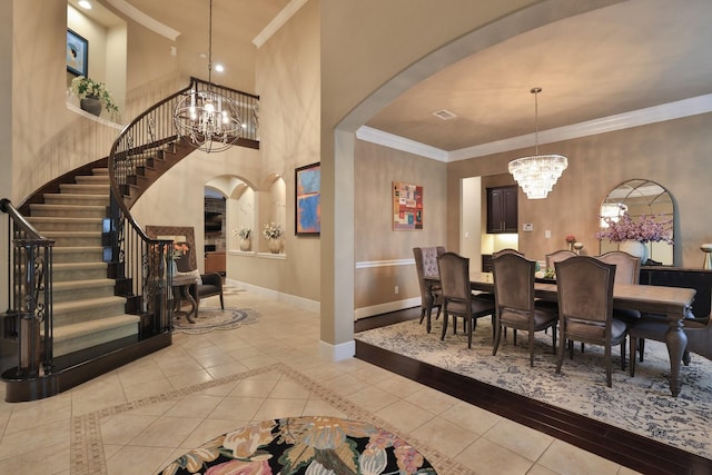 15614 Lake Iris Dr, Houston, TX 77070 - dining space featuring arched walkways, a chandelier, stairway, crown molding, and a towering ceiling
