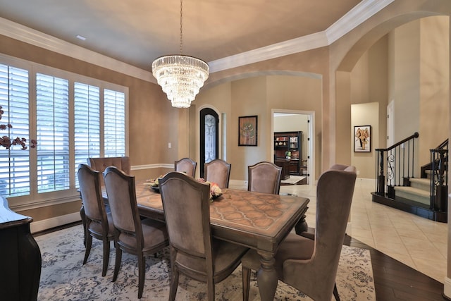 15614 Lake Iris Dr, Houston, TX 77070 - dining space featuring arched walkways, a chandelier, ornamental molding, stairs, and wood finished floors