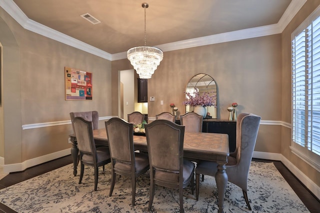 15614 Lake Iris Dr, Houston, TX 77070 - dining area with a chandelier, wood finished floors, arched walkways, and ornamental molding