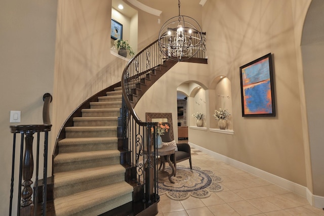 15614 Lake Iris Dr, Houston, TX 77070 - staircase featuring arched walkways, tile patterned floors, a chandelier, and a high ceiling