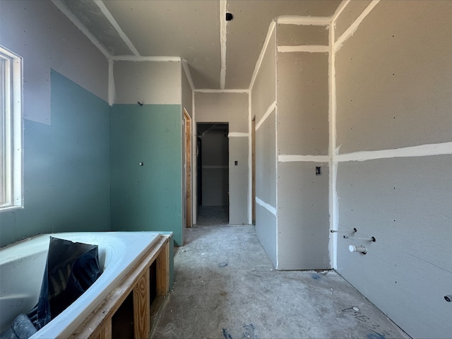 interior space with concrete floors and a bath