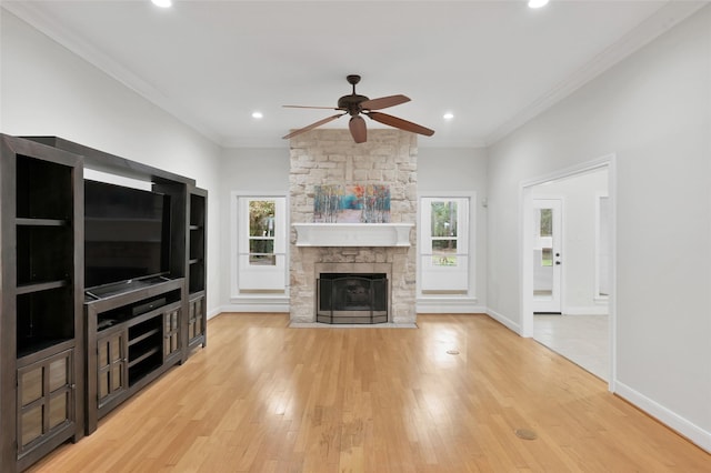 14 Wind River Dr, Conroe, TX 77384 - unfurnished living room featuring a ceiling fan, ornamental molding, light wood-type flooring, recessed lighting, and a stone fireplace