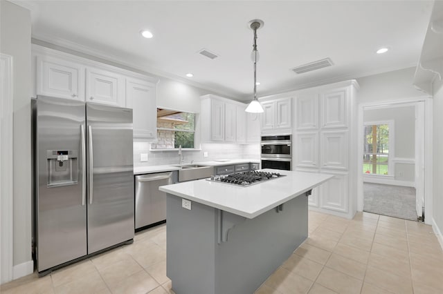 14 Wind River Dr, Conroe, TX 77384 - kitchen featuring appliances with stainless steel finishes, a sink, white cabinetry, a center island, and light tile patterned floors