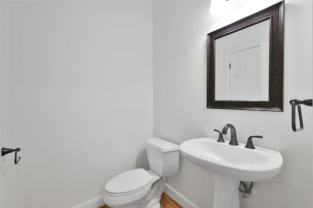 14 Wind River Dr, Conroe, TX 77384 - half bathroom featuring baseboards, toilet, wood finished floors, and a sink
