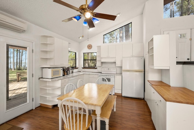 kitchen with open shelves, white appliances, an AC wall unit, under cabinet range hood, and a ceiling fan