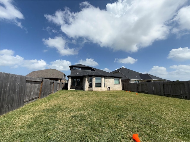 2412 Elliott Shore Ln, La Porte, TX 77571 - back of house with a fenced backyard, a lawn, and brick siding