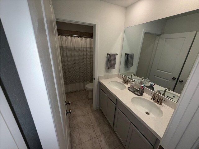 2412 Elliott Shore Ln, La Porte, TX 77571 - bathroom with double vanity, a sink, toilet, and tile patterned floors