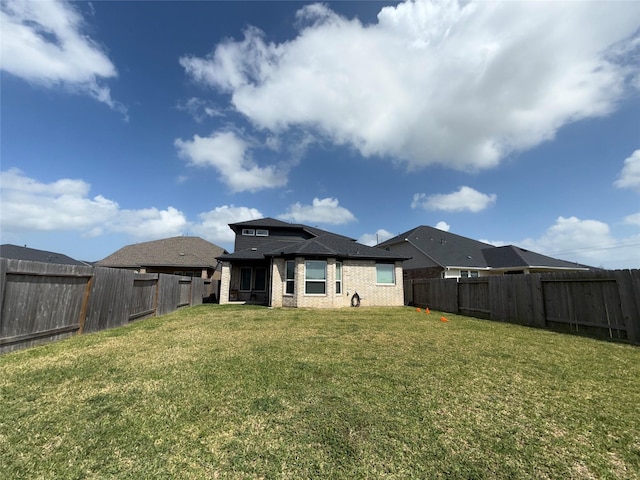 2412 Elliott Shore Ln, La Porte, TX 77571 - rear view of property featuring a fenced backyard, brick siding, and a yard