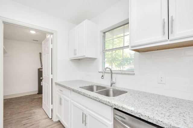 1501 Maiden Ln, Richmond, TX 77469 - kitchen with white cabinets, a sink, tasteful backsplash, and light stone countertops