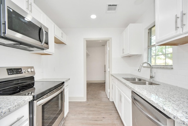 1501 Maiden Ln, Richmond, TX 77469 - kitchen featuring a sink, appliances with stainless steel finishes, light stone countertops, and visible vents