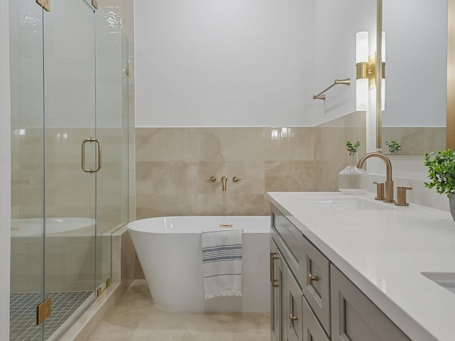 full bathroom with vanity, a shower stall, and tile walls