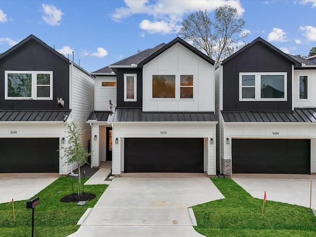 modern farmhouse with an attached garage, a standing seam roof, metal roof, and driveway