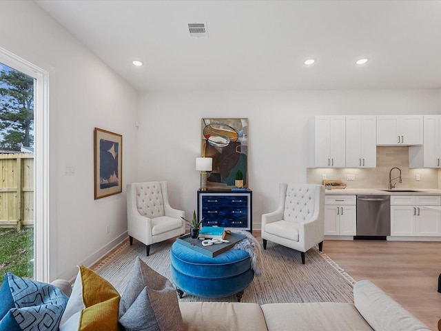 living room with recessed lighting, baseboards, visible vents, and light wood-style floors