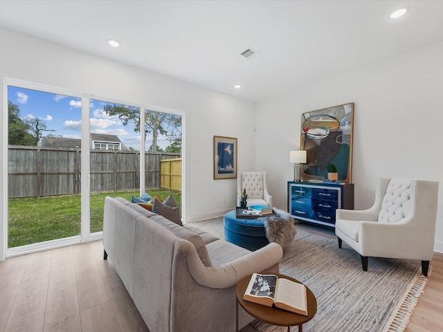 living area with recessed lighting, wood finished floors, and visible vents