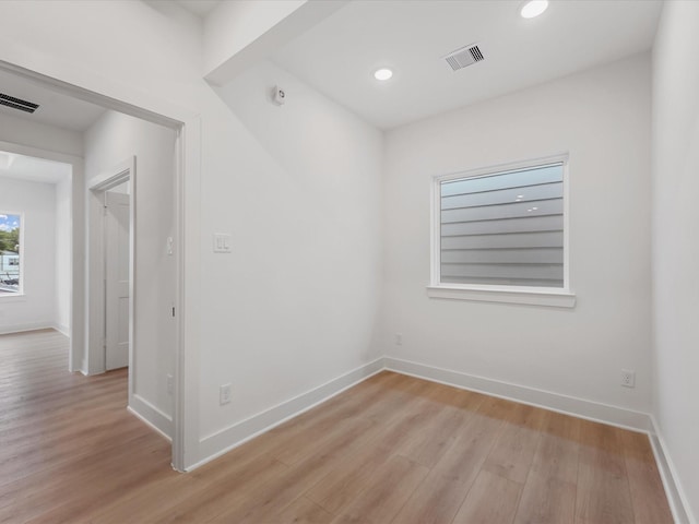 spare room featuring baseboards, visible vents, and light wood-style flooring