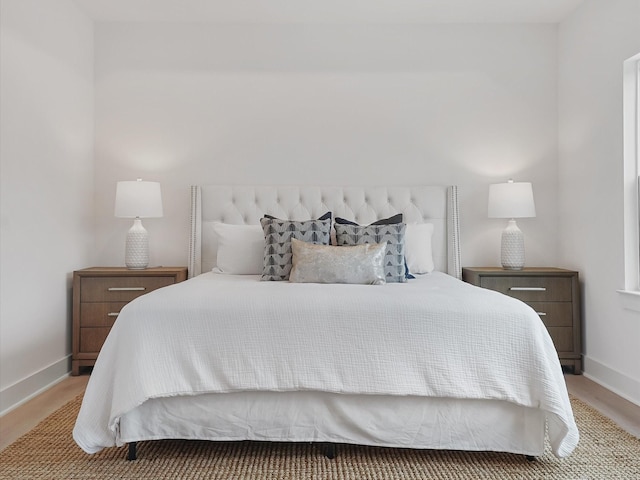 bedroom with baseboards and wood finished floors
