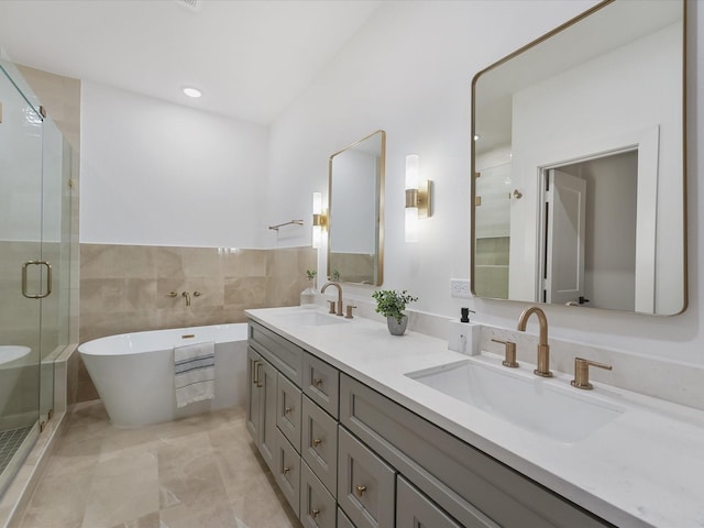 bathroom featuring double vanity, a freestanding bath, a sink, and a stall shower