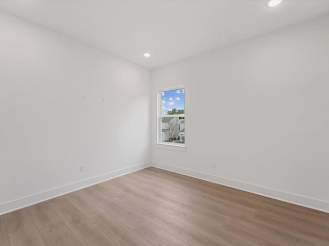 unfurnished room with light wood-style floors, baseboards, and recessed lighting