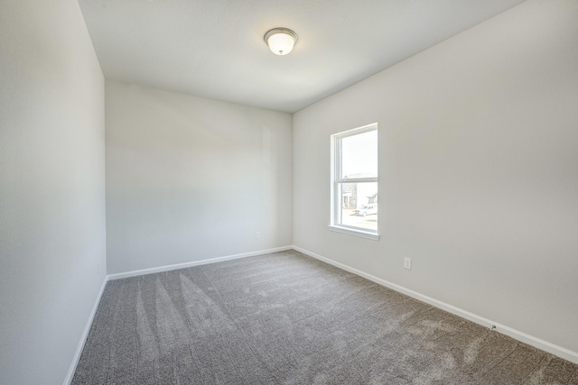 empty room featuring carpet floors and baseboards