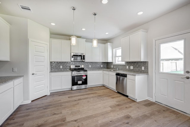 kitchen featuring backsplash, stainless steel appliances, and white cabinetry