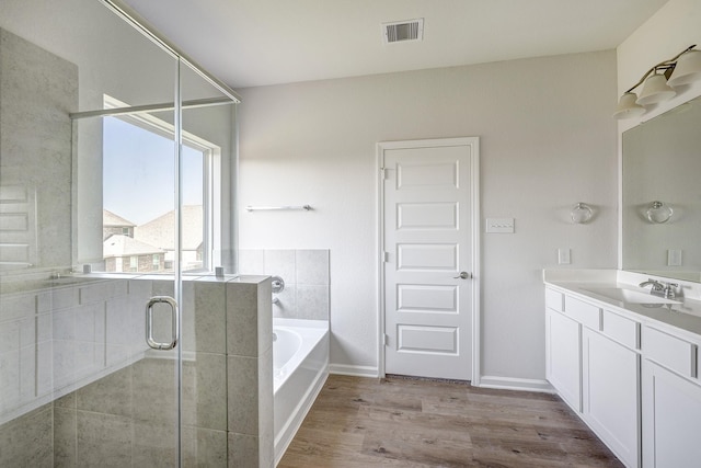 bathroom featuring vanity, wood finished floors, visible vents, a garden tub, and a stall shower