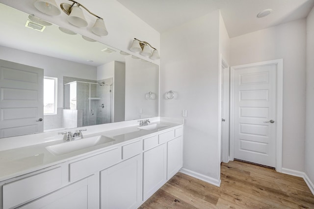full bathroom with a sink, baseboards, a stall shower, and visible vents