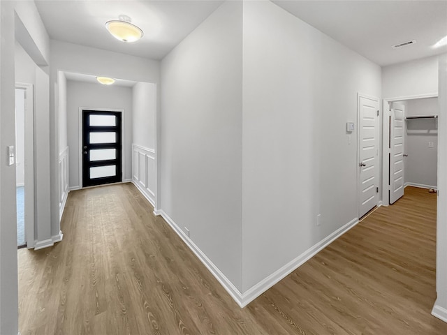 hall featuring wood finished floors and baseboards