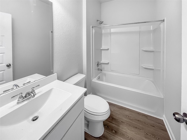 bathroom featuring wood finished floors, toilet, vanity, and bathtub / shower combination