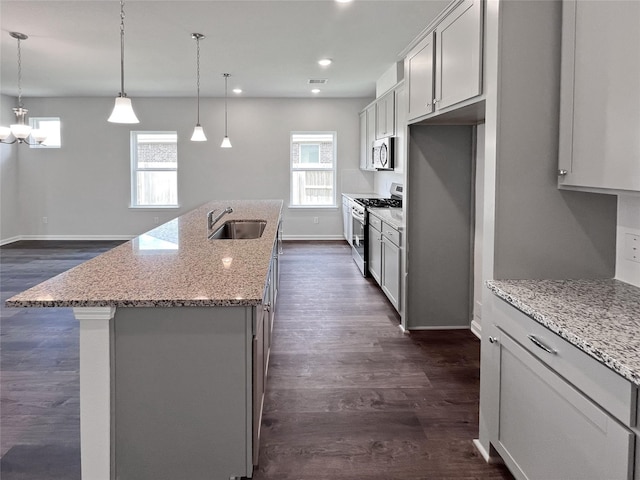 1907 Temple Grove Dr, Iowa Colony, TX 77583 - kitchen with appliances with stainless steel finishes, a sink, baseboards, dark wood-style floors, and an island with sink