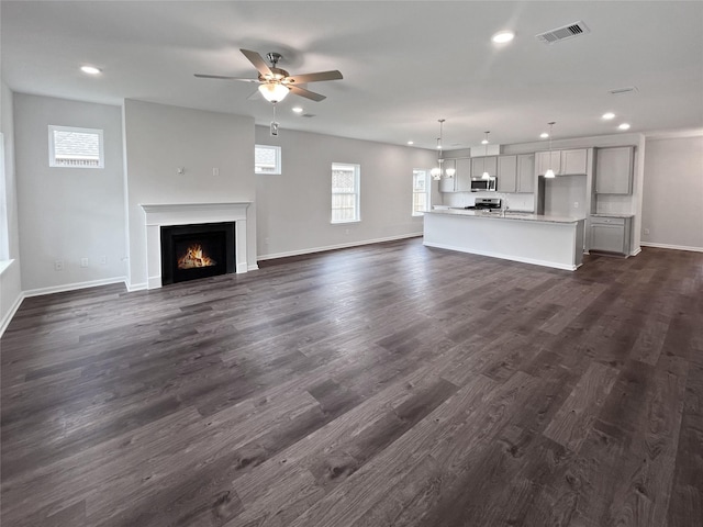 1907 Temple Grove Dr, Iowa Colony, TX 77583 - unfurnished living room featuring recessed lighting, baseboards, a lit fireplace, ceiling fan, and dark wood-style floors