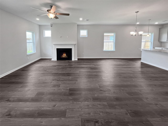 1907 Temple Grove Dr, Iowa Colony, TX 77583 - unfurnished living room featuring a warm lit fireplace, a ceiling fan, a chandelier, recessed lighting, and dark wood finished floors