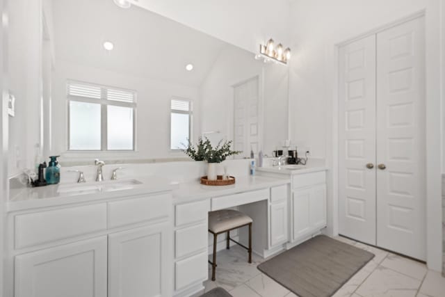 full bathroom featuring marble finish floor, a sink, double vanity, and lofted ceiling