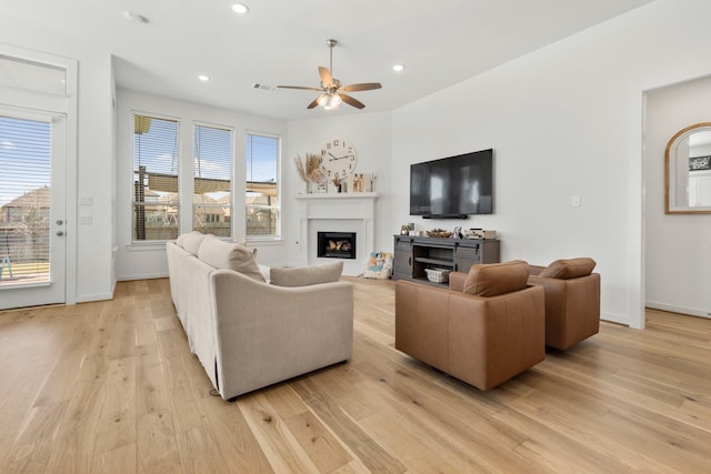 living room with a fireplace, recessed lighting, a ceiling fan, and light wood finished floors